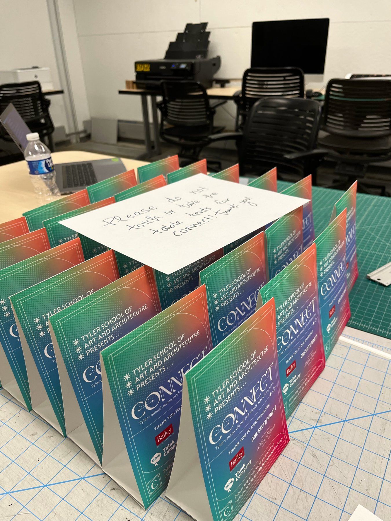 Scored and folded table tents drying on the cutting mat in the print studio
