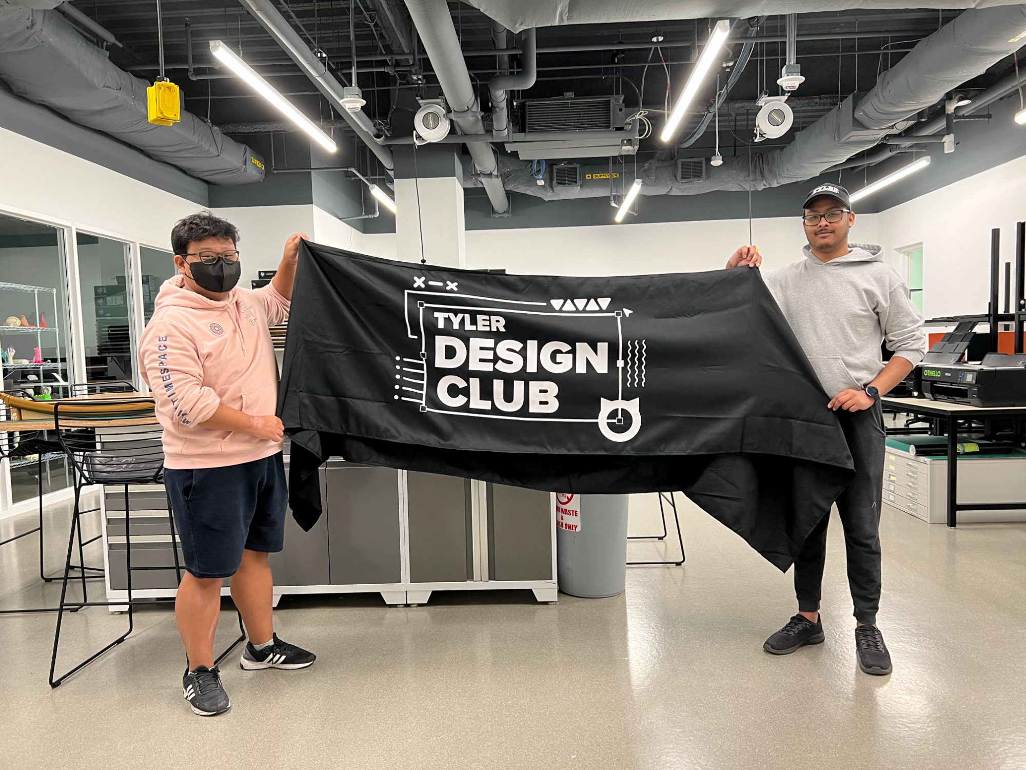 Club members holding the finished Tyler Design Club banner
