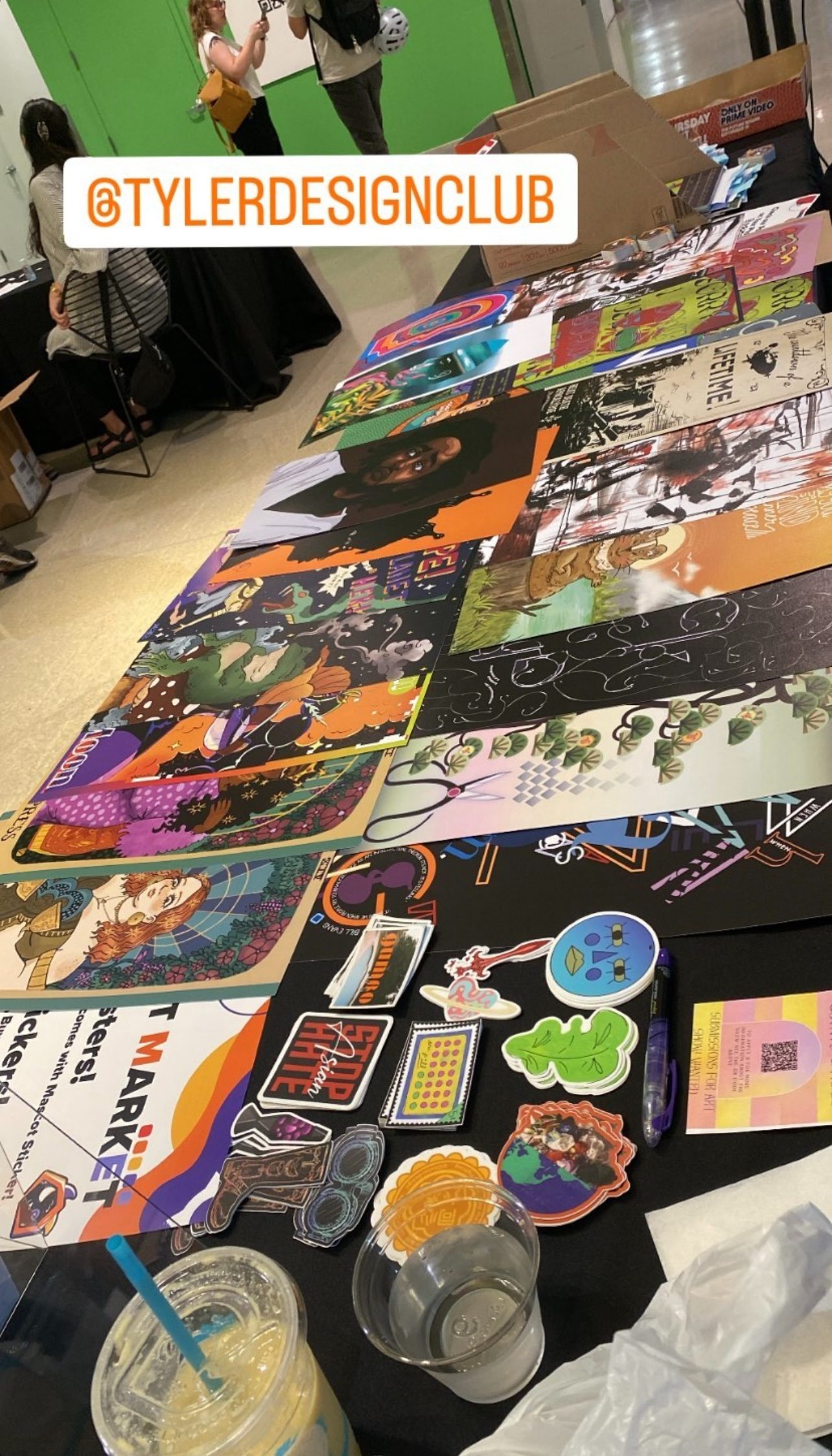 Members&rsquo; posters and stickers laid out across the booth table